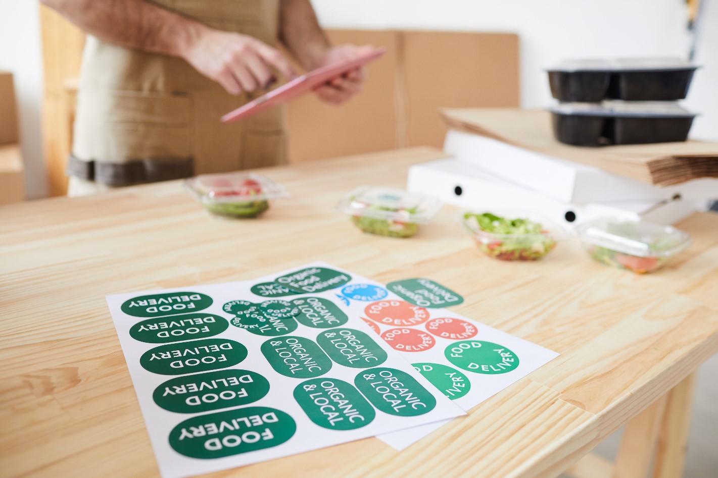 A man is putting stickers on a wooden table.