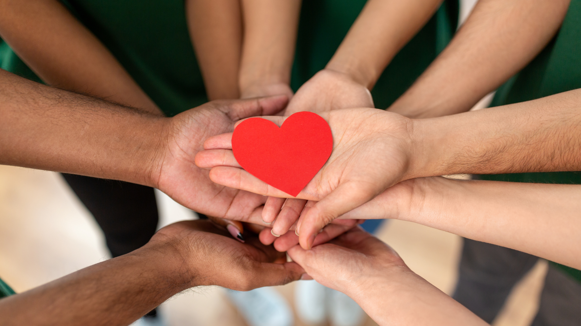 A group of hands holding a red heart, representing the compassion and support shown by nonprofits.