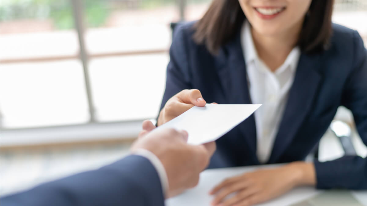 A Person Handing A Piece of Paper