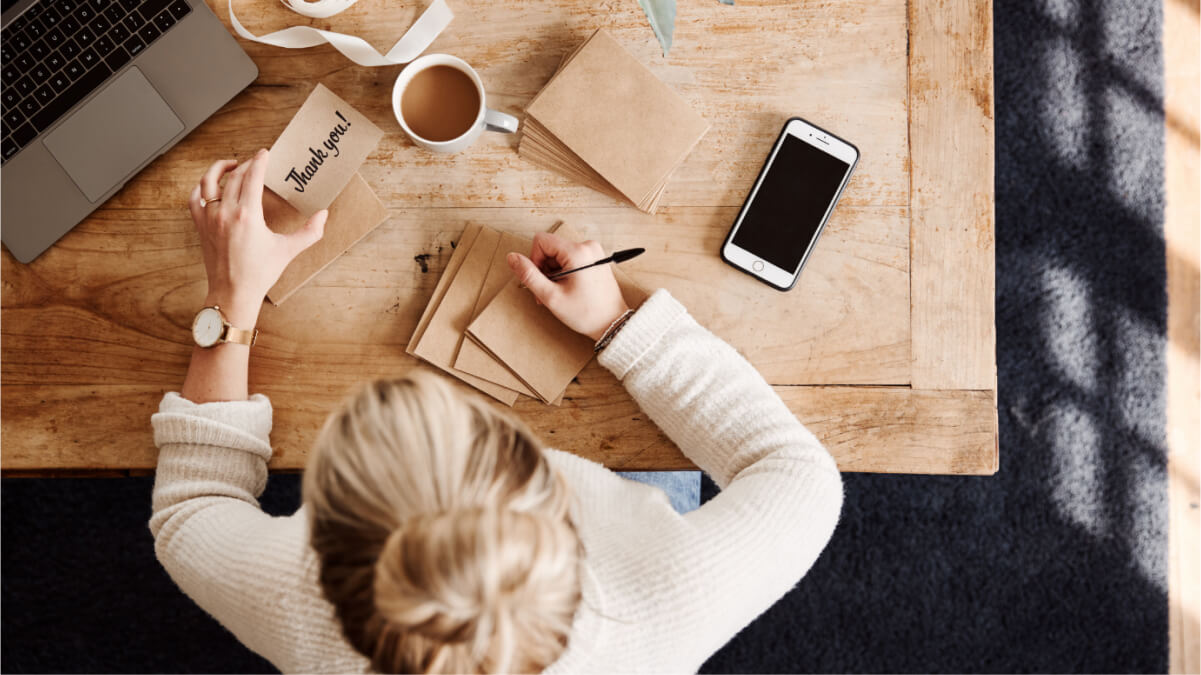 A Person Writing A Letter on a Table