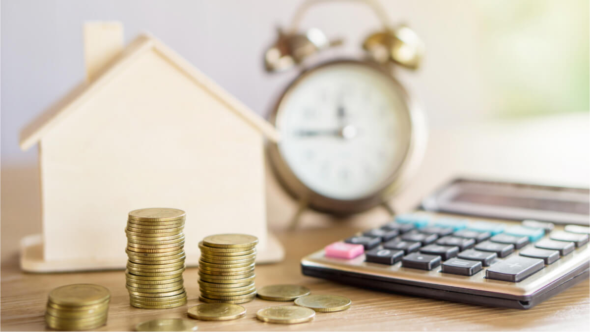 A stack of coins next to a calculator and a clock