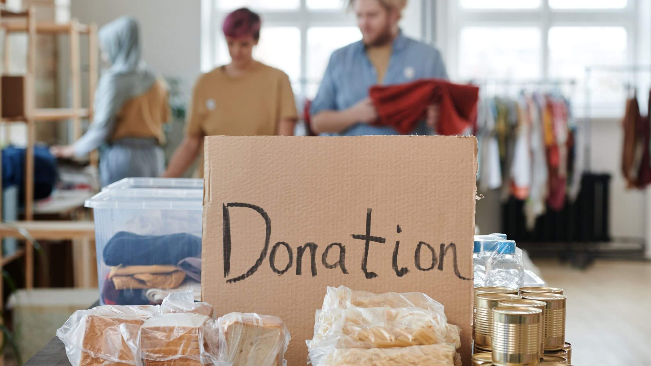 A group of people standing in front of a donation box