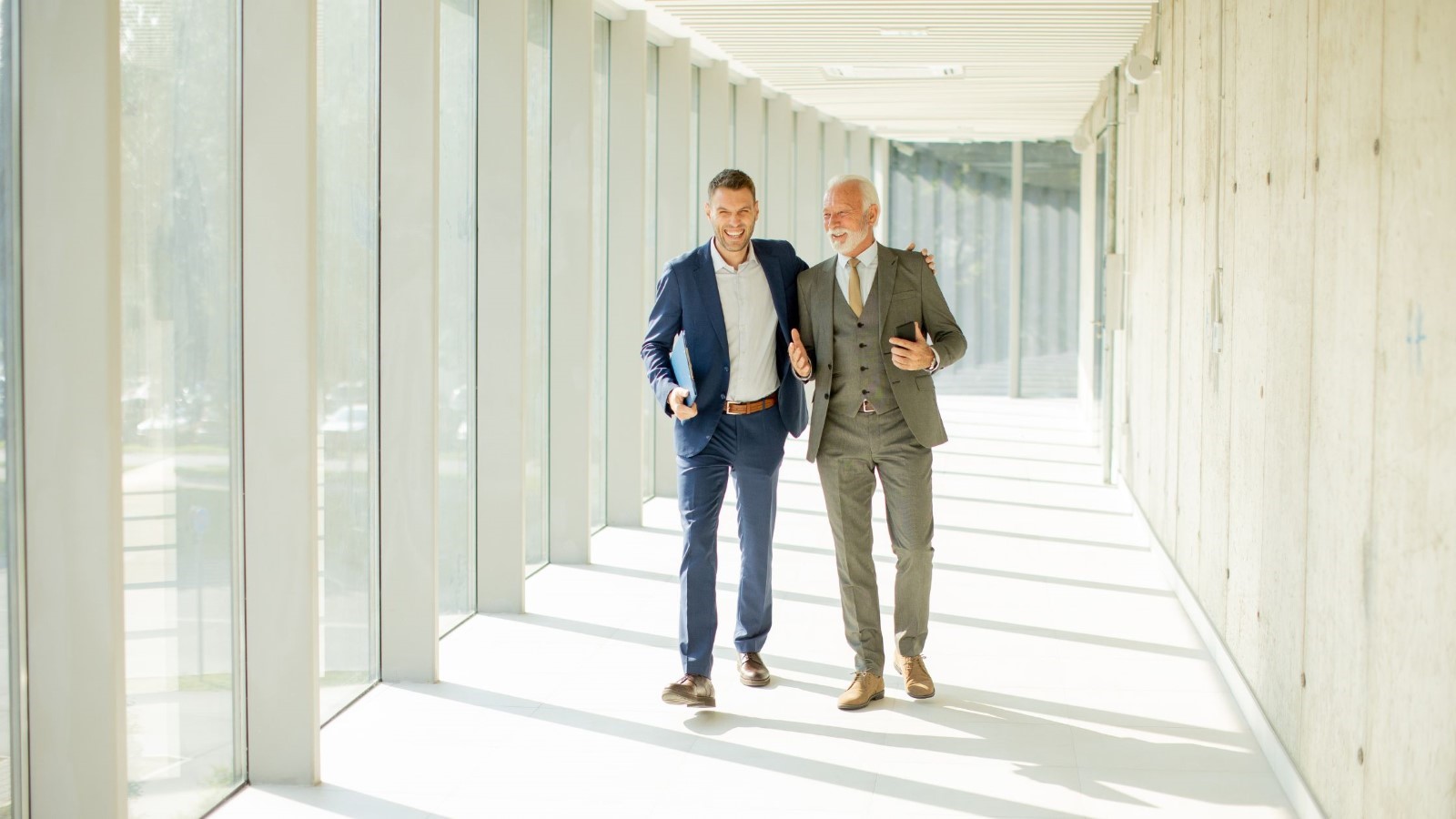 Men in suits walking down a hallway