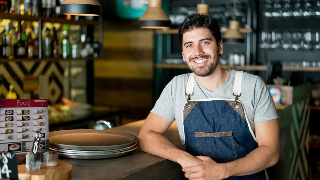 Man wearing apron smiling - Restaurant
