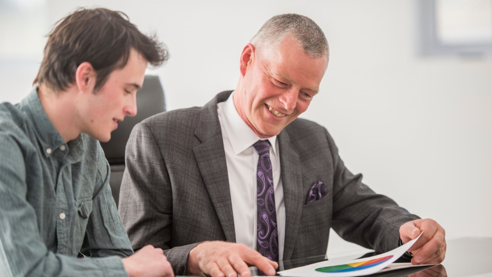 A person in suit looking at a paper