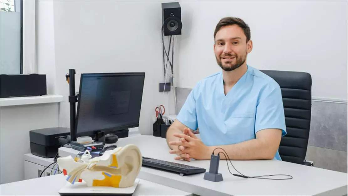 A person sitting at a desk with a computer - Patient Care