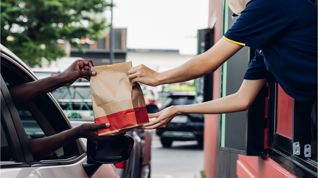 Fast food crew giving a customer's order in the drive-thru