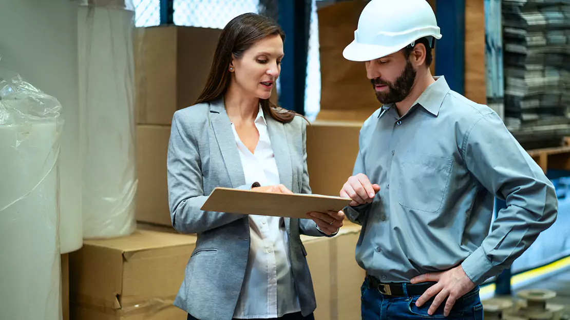 Two people looking at clip board