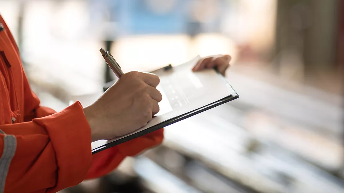 A person writing on a clipboard