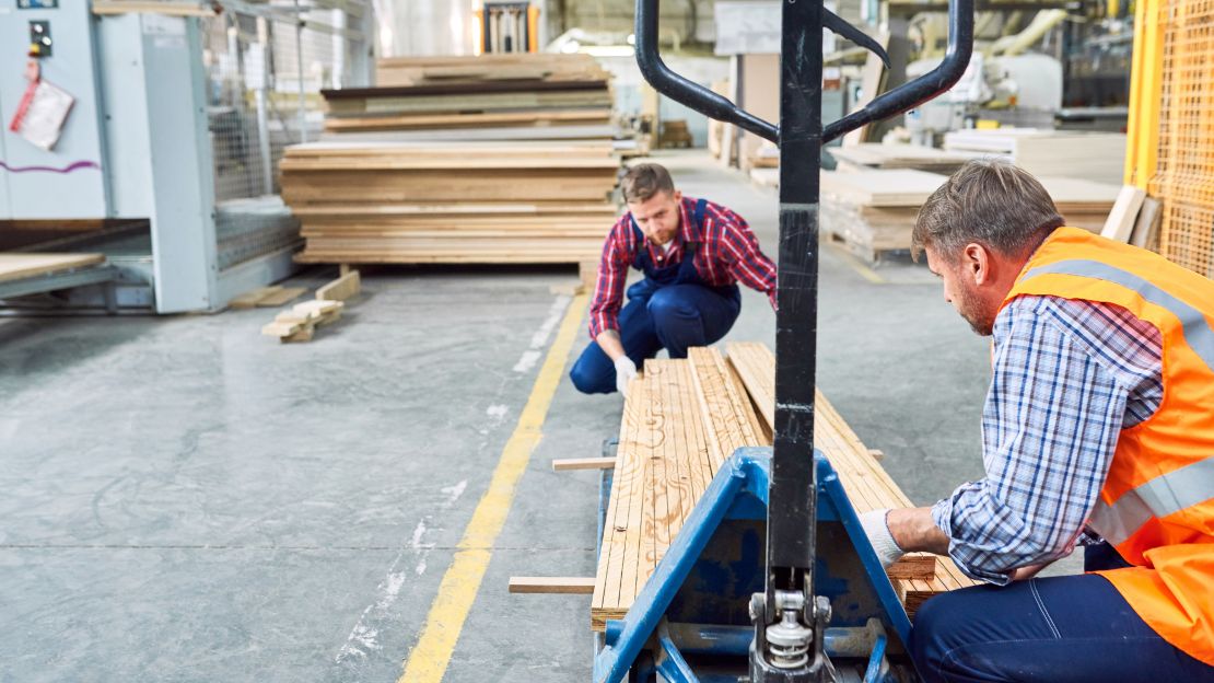 Workers are stacking the wood supplies.
