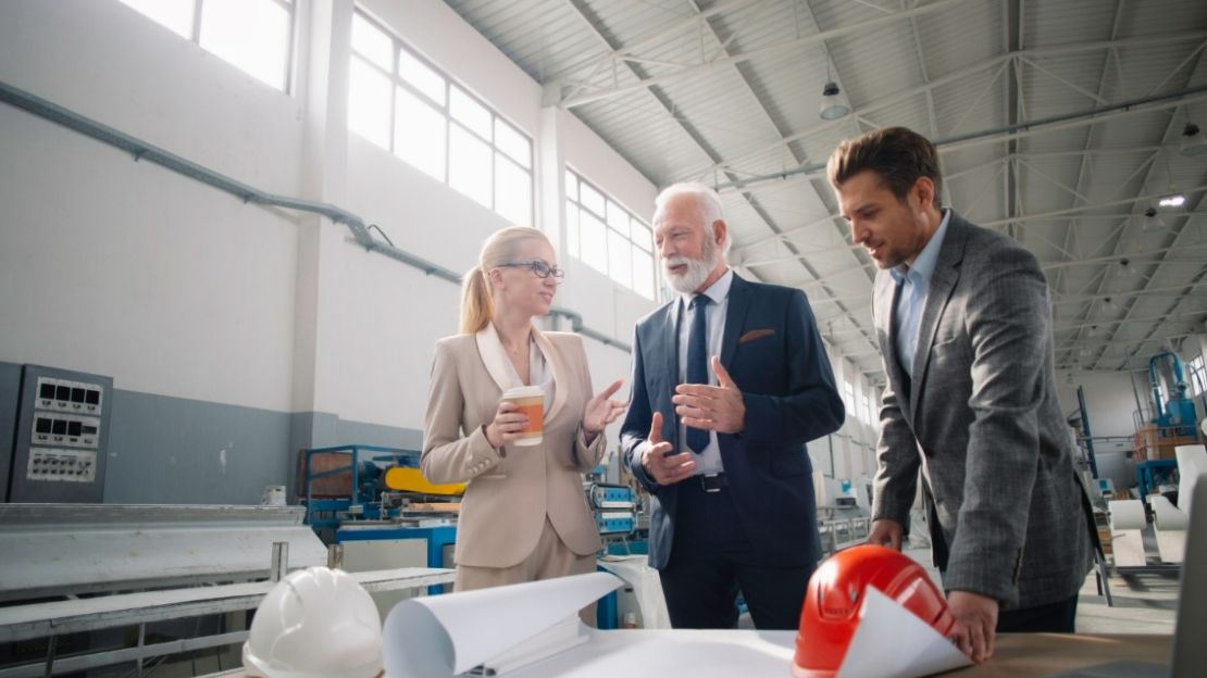 Three people are having a discussion about their manufacturing plans