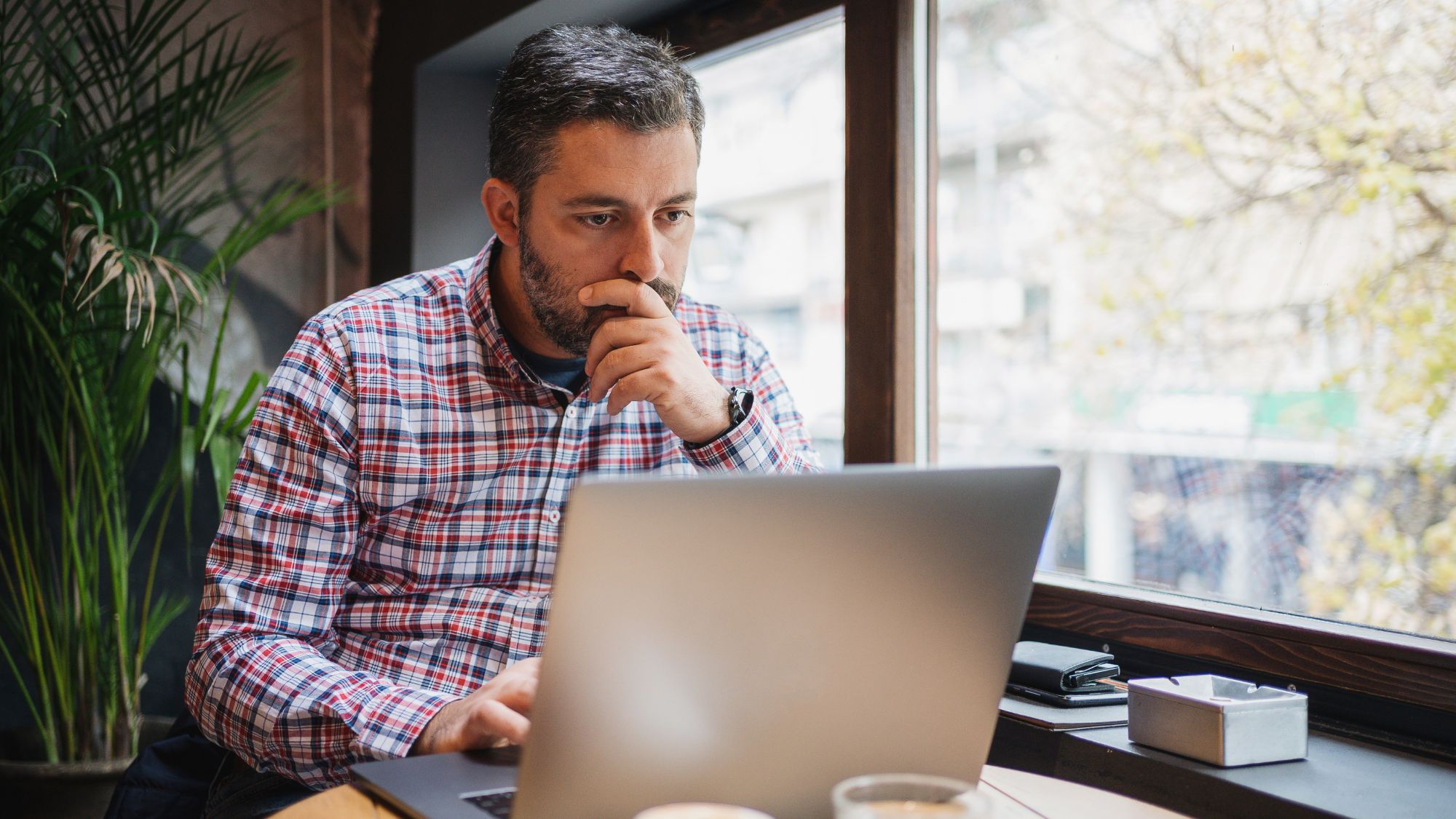 A middle-aged man staring at his laptop