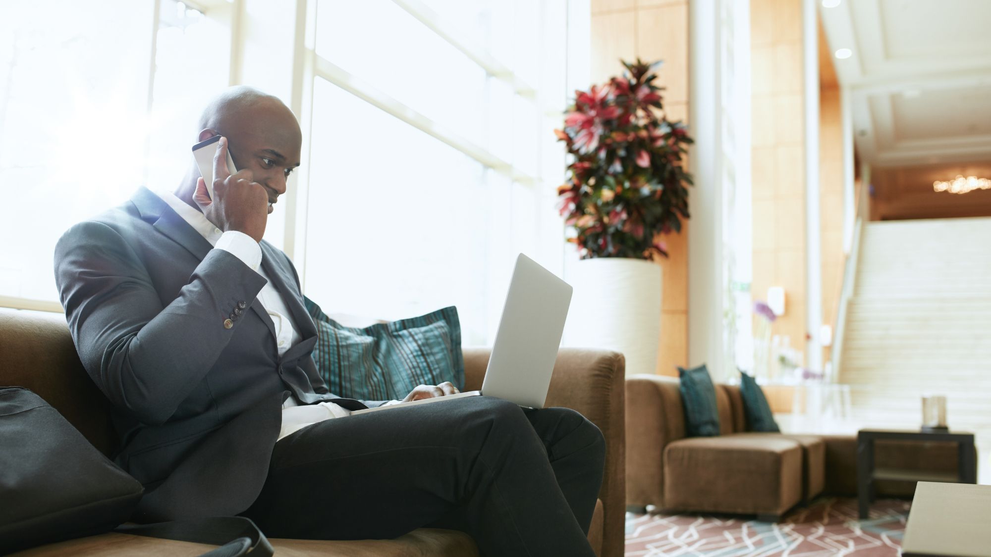 Business traveler working on a laptop in a hotel lobby