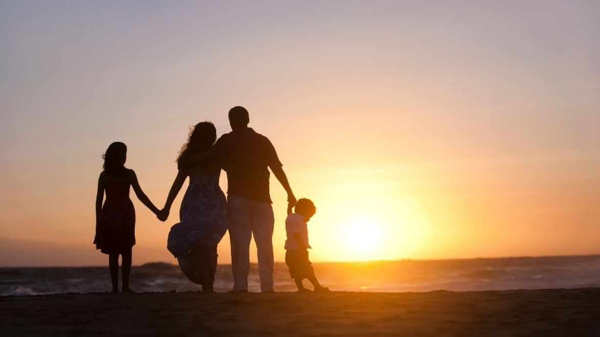 Family watching the sunset together at the beach