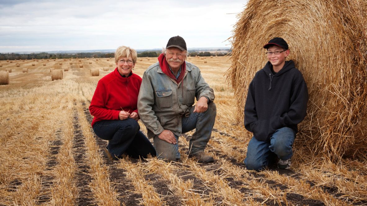 Older couple with teenager in a farm field