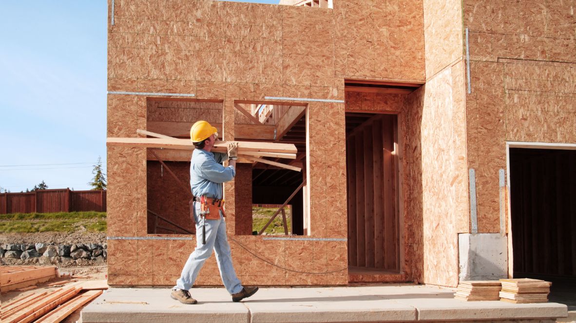 Construction worker carrying wooden boards