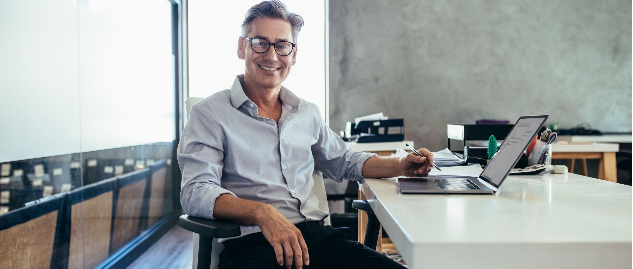 Retired man smiling at his desk