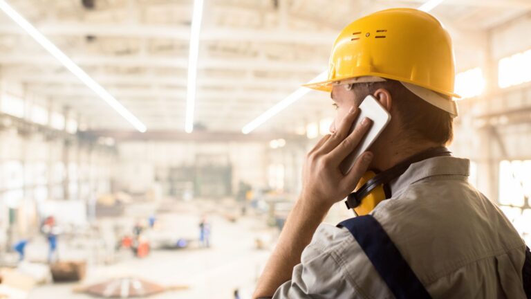 Worker wearing a hard hat and talking on the phone