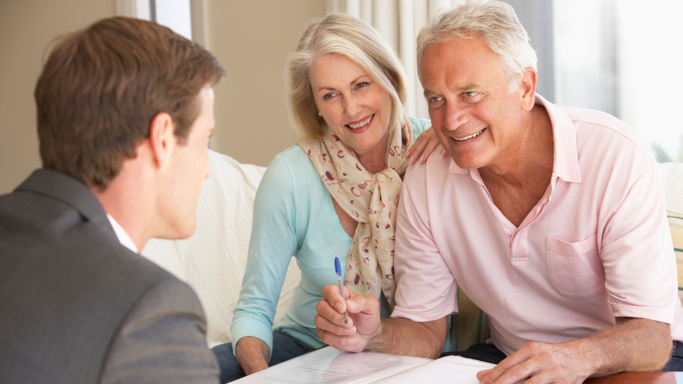 Couple talking to an advisor and holds a pen