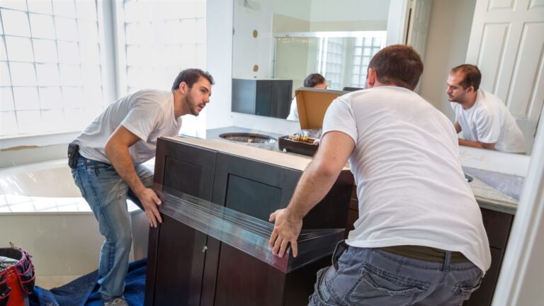 Two men carrying a bathroom cabinet